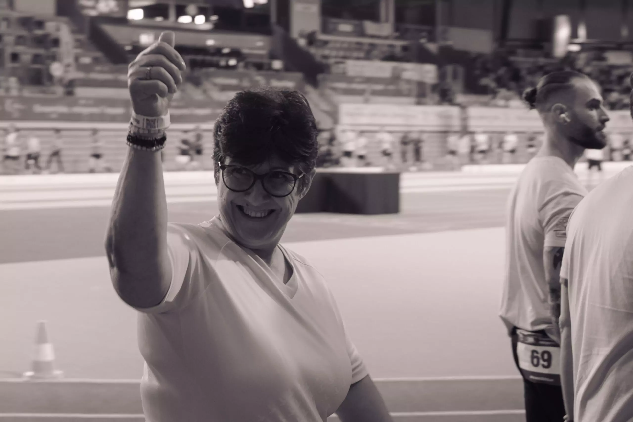 ALGSO member, Gena, walking during the Relais pour la Vie 2026 Luxembourg, and giving a thumbs-up to the ALGSO team in the bleachers.