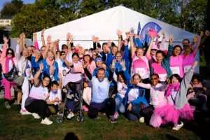 Team ALGSO at the Broschtkriibslaf 2026 in Hesperange, all gathered and raising their hands in the air.